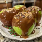 Close-up of juicy candy apple slices drizzled with chocolate and topped with sprinkles.