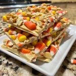 Close-up view of Candy Corn Peanut Bark showcasing colorful candy corn and peanuts on a white chocolate base.
