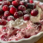 Close-up view of a creamy cranberry cheesecake dip in a bowl.