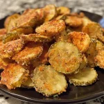 Close-up of crispy fried pickles arranged on a plate.