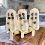 A close-up of healthy Halloween banana ghost pops with chocolate chip eyes.