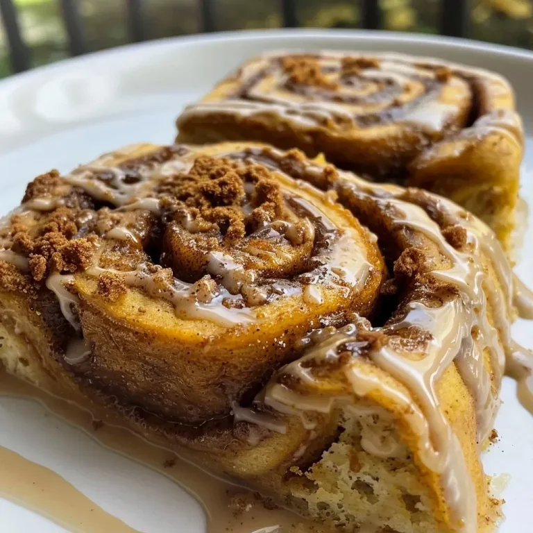 Close-up view of a warm, swirled pumpkin spice latte cinnamon roll with cinnamon sugar topping.