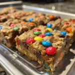 Close-up view of Monster Cookie Bars with chocolate chips and M&Ms.