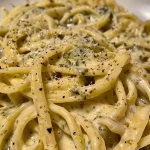 Creamy Pesto Sauce in a white bowl with fresh basil.