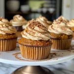 Close-up side view of a pumpkin chai cupcake topped with creamy frosting.