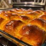 Close-up side view of golden Pumpkin Dinner Rolls with a soft texture and visible pepitas.