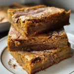 Close-up of golden brown pumpkin spice blondies with chocolate chips and toffee drizzle.
