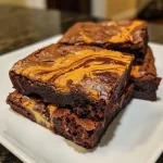 Close-up view of a decadent pumpkin spice swirl brownie with a rich, chocolatey exterior and creamy swirls.