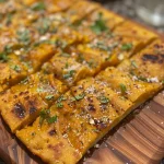 Close-up of a sliced Garlic Pumpkin Flatbread with golden-brown crust and visible pumpkin puree.